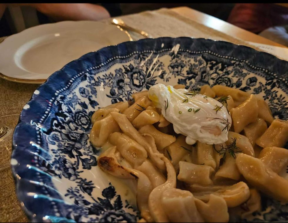 One of those "grandma plates" containing dumplings with sherry cream sauce, wild mushrooms and a poached egg.