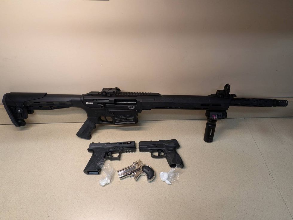 One tactical shotgun, three handguns, and small bags of suspected drugs.