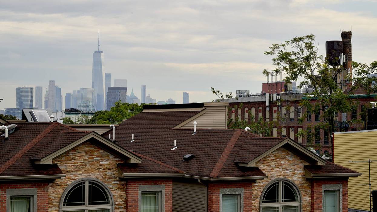 One World Trade Center building behind residential homes in Jersey City, New Jersey.