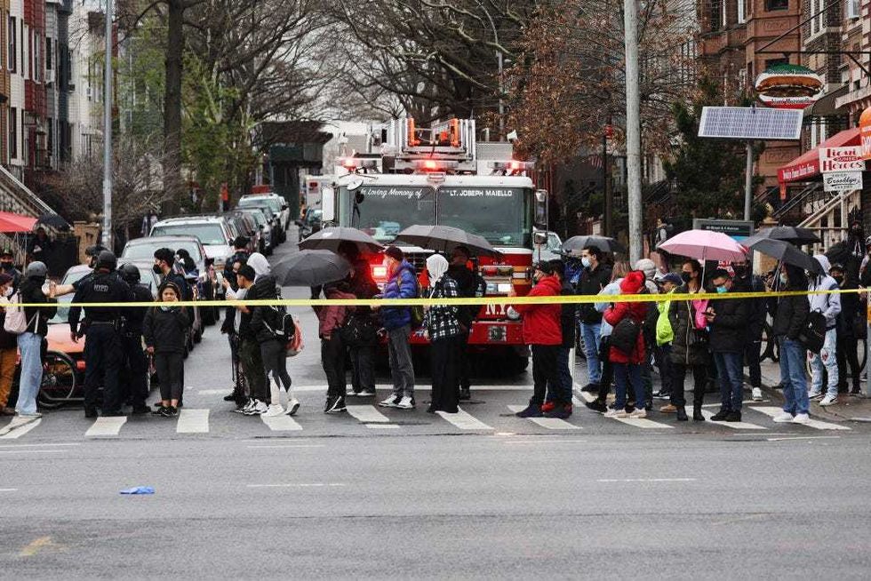 Onlookers watch as police and emergency responders gather at the site of a reported shooting of multiple people outside of the 36 St subway station on April 12, 2022 in the Brooklyn borough of New York City