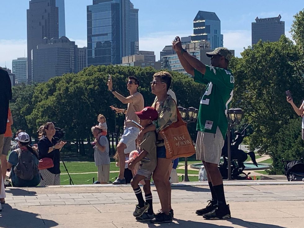 Onlookers watch the Italian Air Force Frecce Tricolori flyover from the top of the Art Museum steps.