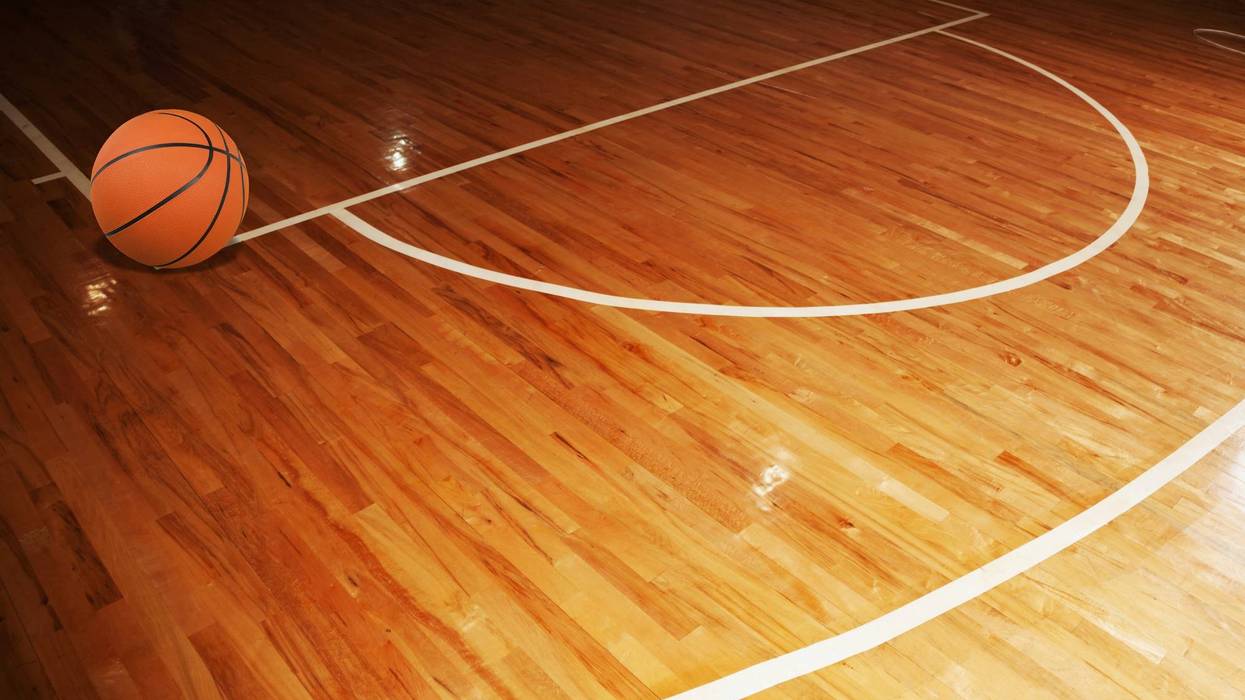 Orange basketball on a polished hardwood court with white lines.