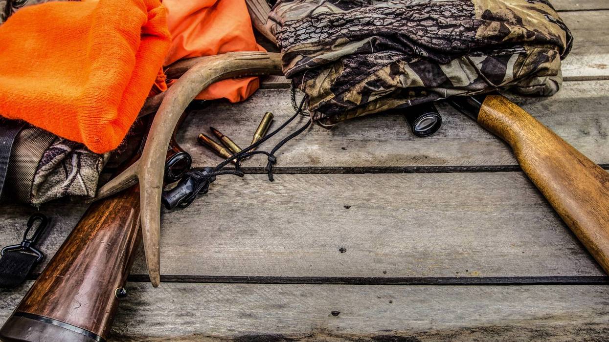 Orange hunting vest, camo and guns