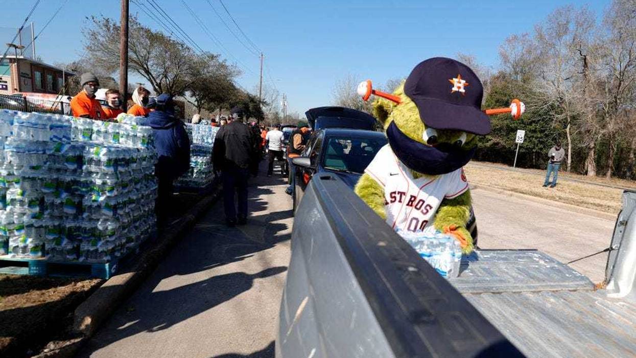 Orbit, the Houston Astros mascot, loads a case of water into a truck during a water distribution at the Astros Youth Academy on February 20, 2021 in Houston, Texas. Much of Texas is still struggling with historic cold weather, power outages and a shortage of potable water after winter storm Uri swept across 26 states with a mix of freezing temperatures and precipitation.