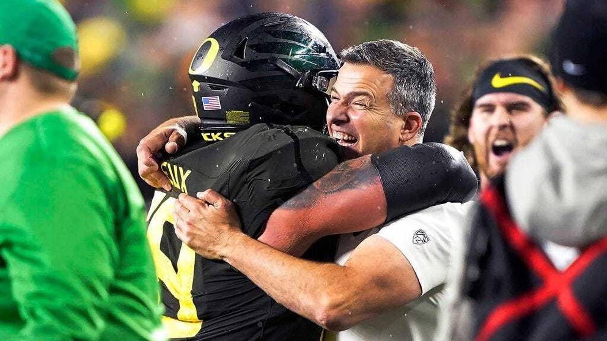 Oregon coach Mario Cristobal, right, celebrates with offensive lineman Shane Lemieux