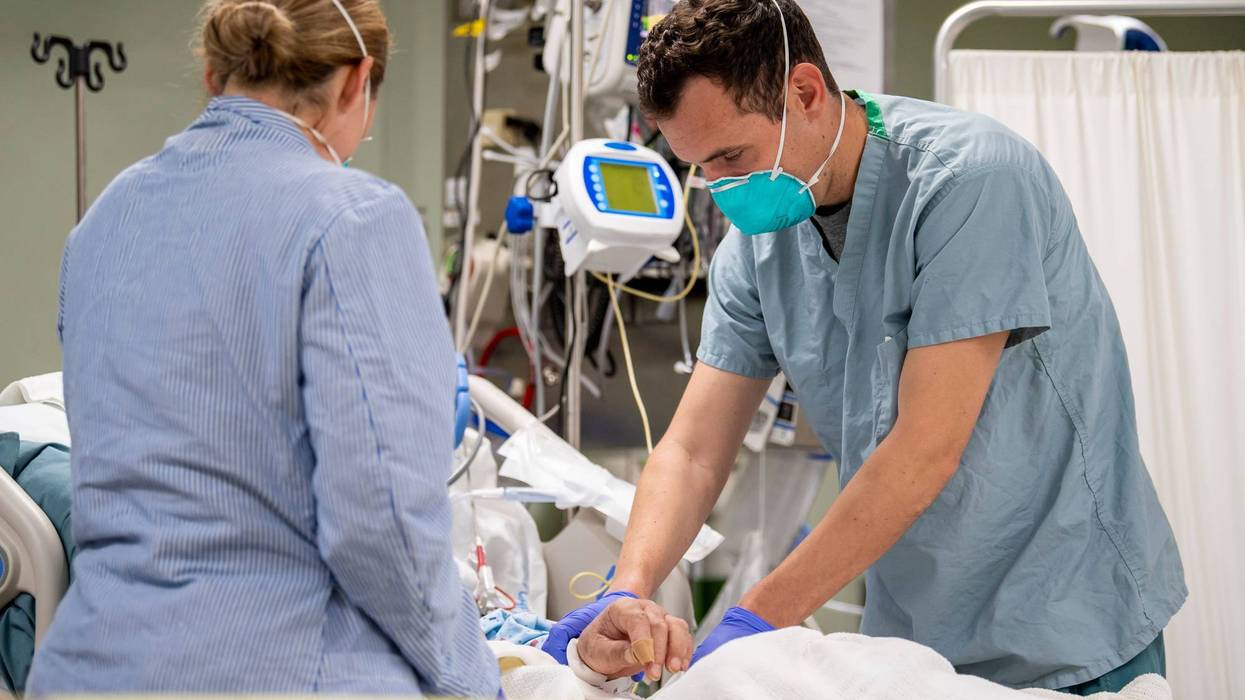 OS ANGELES, CA - APRIL 04: In this handout released by the U.S. Navy, Lt. Wade Miller, from Orlando, Fla., treats a patient aboard the hospital ship USNS Mercy (T-AH 19), April 4, 2020.
