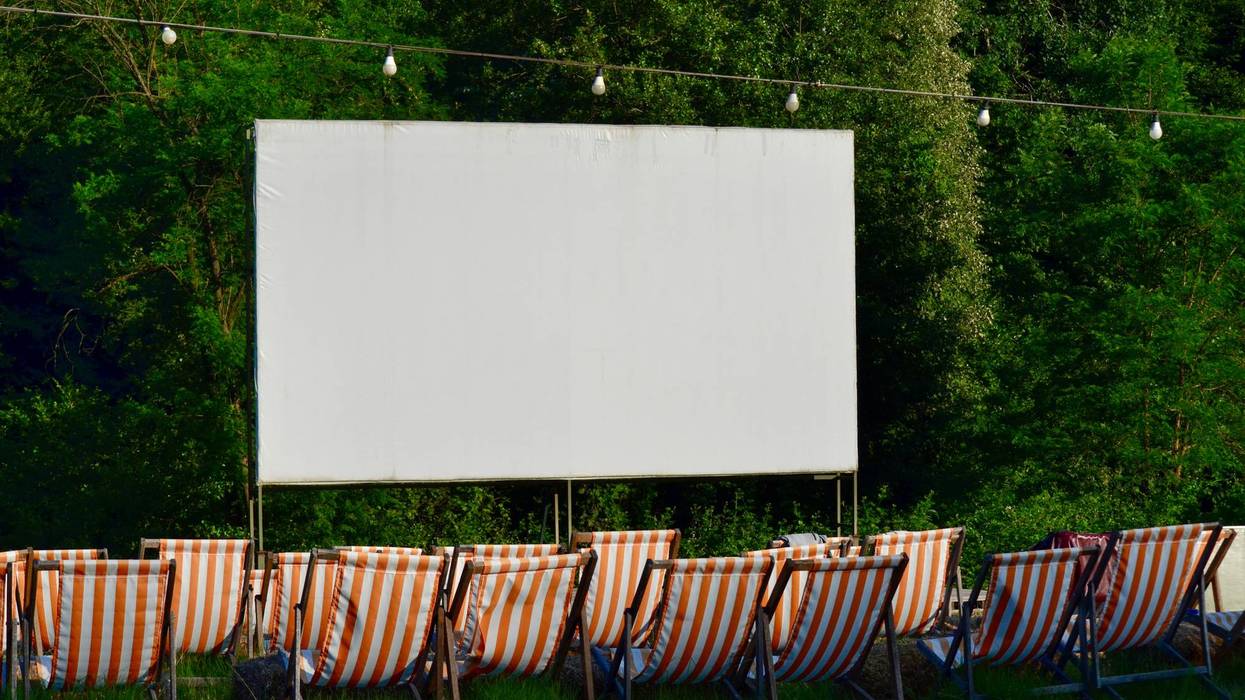Outdoor cinema with striped deck chairs in forest