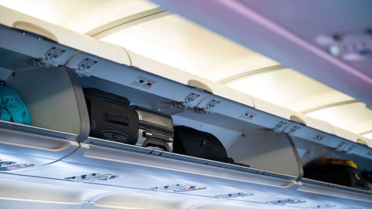 Overhead bin compartment on airplane - stock photo