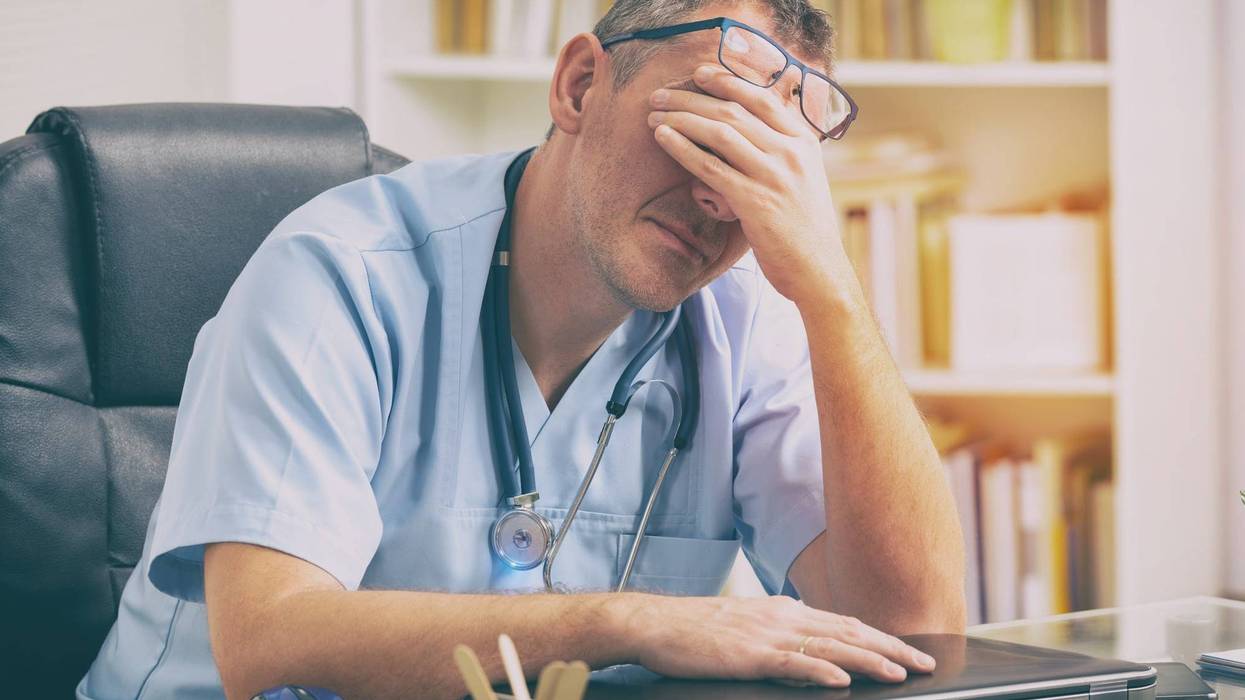 Overworked doctor in his office - stock photo