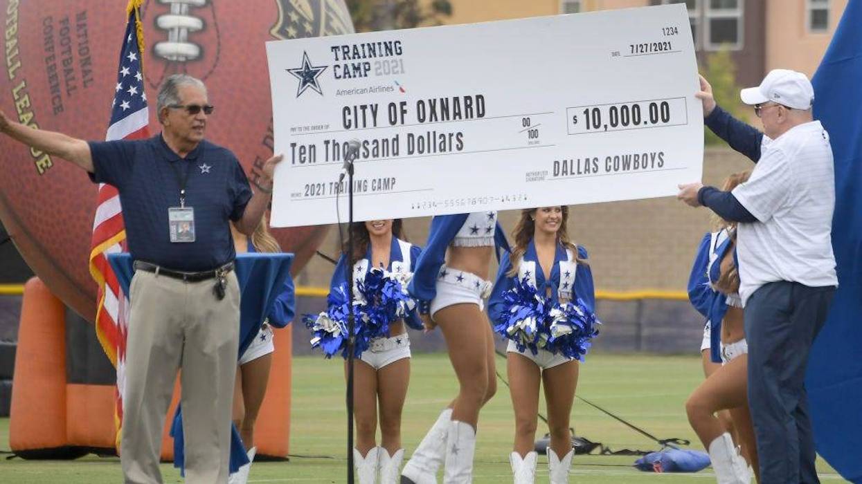 Owner Jerry Jones of the Dallas Cowboys presents a check for the city of Oxnard to the Mayor, John C. Zaragoza, for $10,000 as they welcome fans to training camp at River Ridge Complex on July 24, 2021 in Oxnard, California.