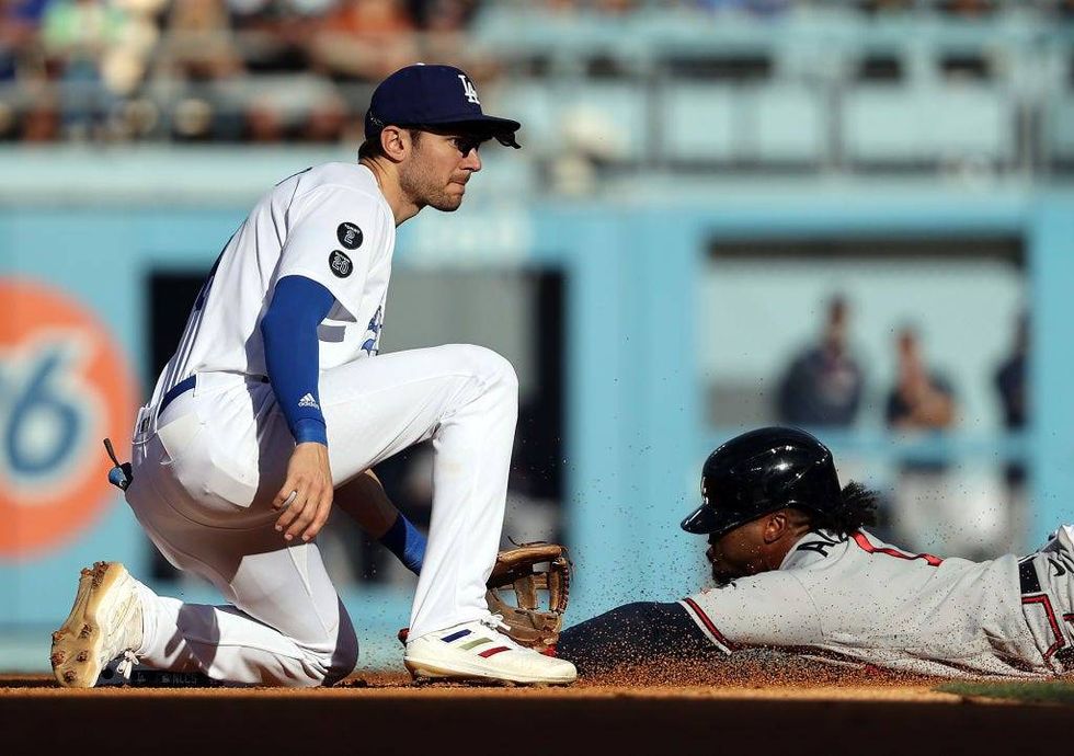 Ozzie Albies #1 of the Atlanta Braves steals second base as Trea Turner #6 of the Los Angeles Dodgers fields the throw during the 5th inning of Game 3.