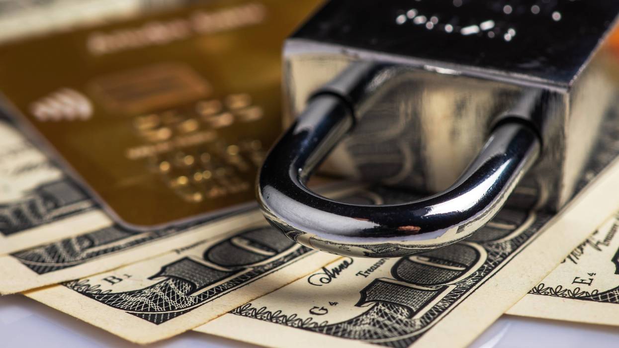 padlock with credit card and hundred dollar bills