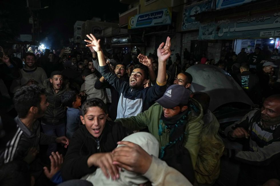 Palestinians celebrate the announcement of a ceasefire deal between Hamas and Israel in Deir al-Balah, central Gaza Strip, Wednesday, Jan. 15, 2025