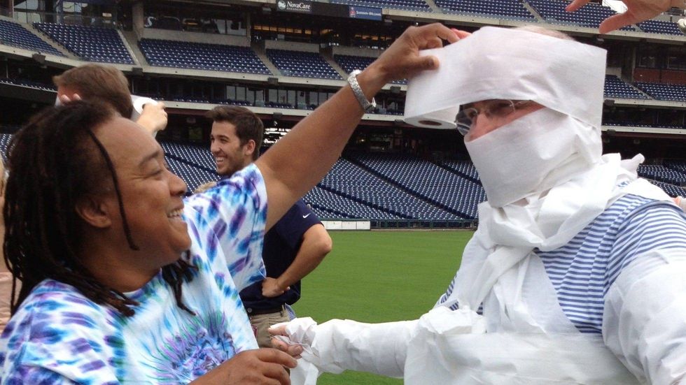 Pam Hall wraps former Phillies President David Montgomery with toilet paper during Phillies employee relay races.
