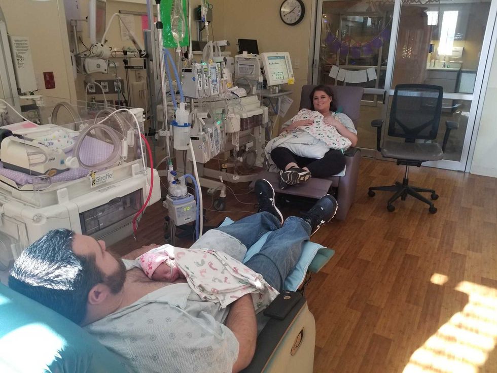 Parents recline in rockers and hold their twins in the hospital NICU