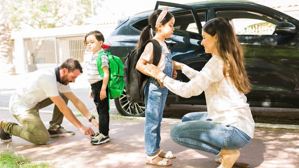 parents smiling and saying goodbye to their little kids before sending them to school in the morning