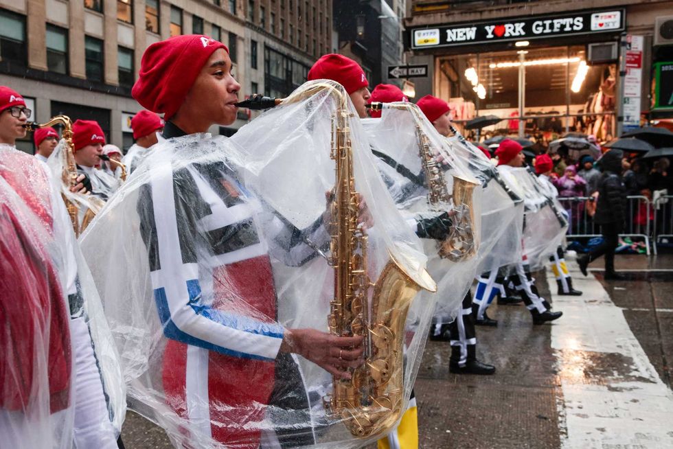 Participants cover their saxophones in plastic bags during the Annual Thanksgiving Day Parade on November 28, 2024 in New York City.