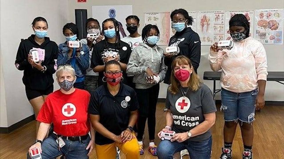 Participants in the HERricane emergency management career program for young women and girls, with American Red Cross team members.