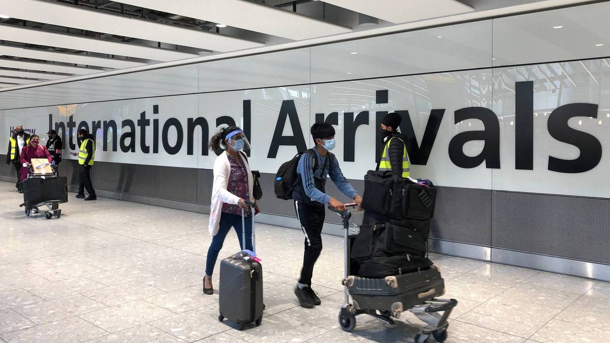 Passengers are escorted through the arrivals area of terminal 5 towards coaches destined for quarantine hotels, after landing at Heathrow airport in London, England