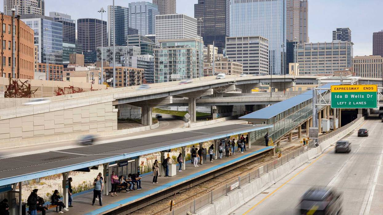 Passengers wait for a CTA Blue Line train at Halsted/UIC as traffic passes on the Eisenhower Expressway and the Jane Byrne Circle Interchange in front of the skyline on Oct. 24, 2022.