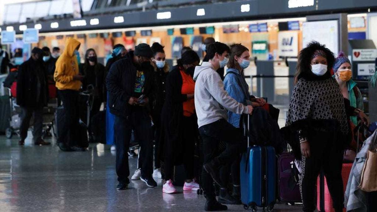 Passengers wait in line to check in for their flights at the Dulles International Airport on December 27, 2021 in Dulles, Virginia.