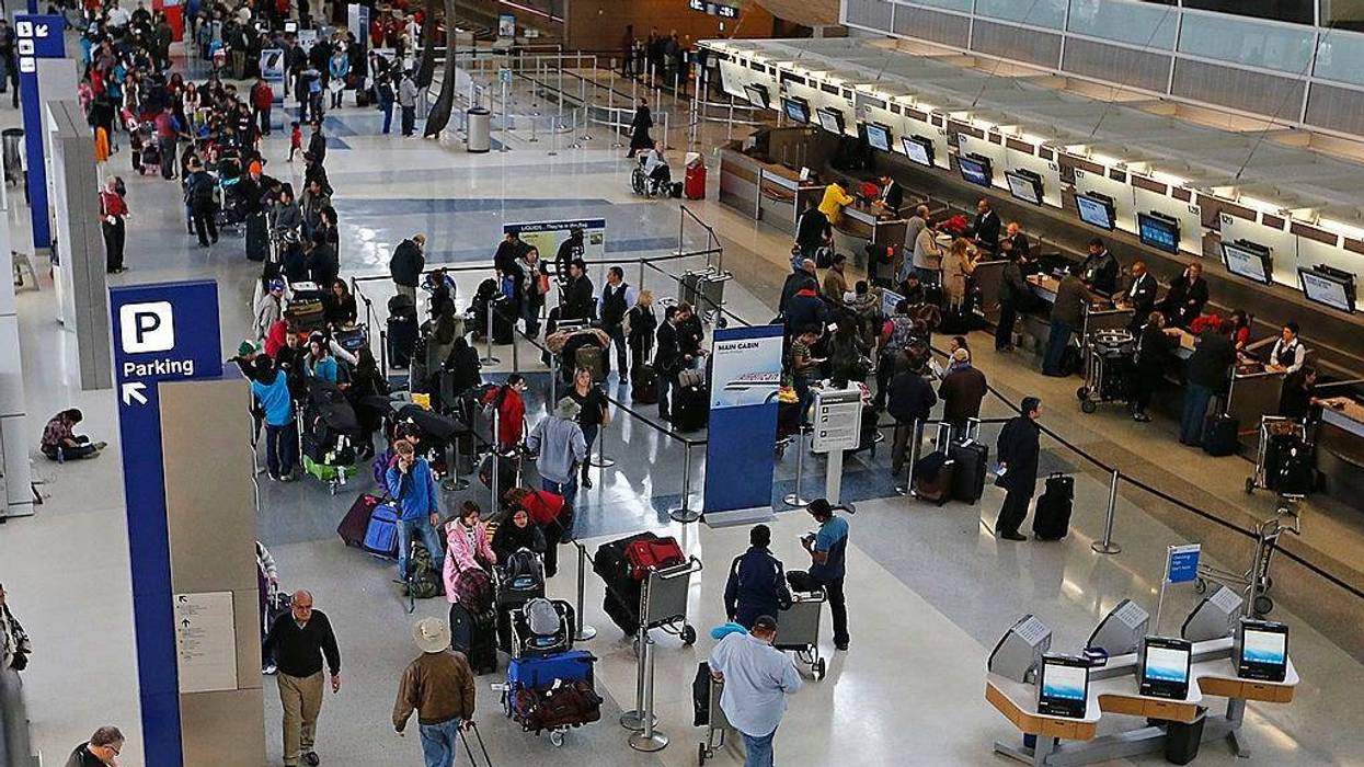 Passengers waiting to speak with ticket agents at American Airlines line the length of Terminal D at DFW International Airport