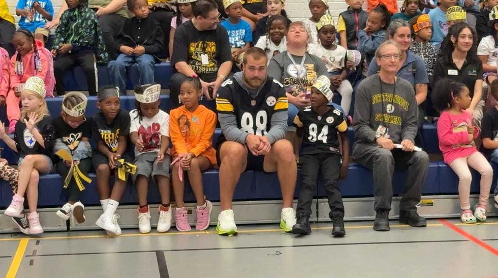 Pat Freiermuth sitting with students