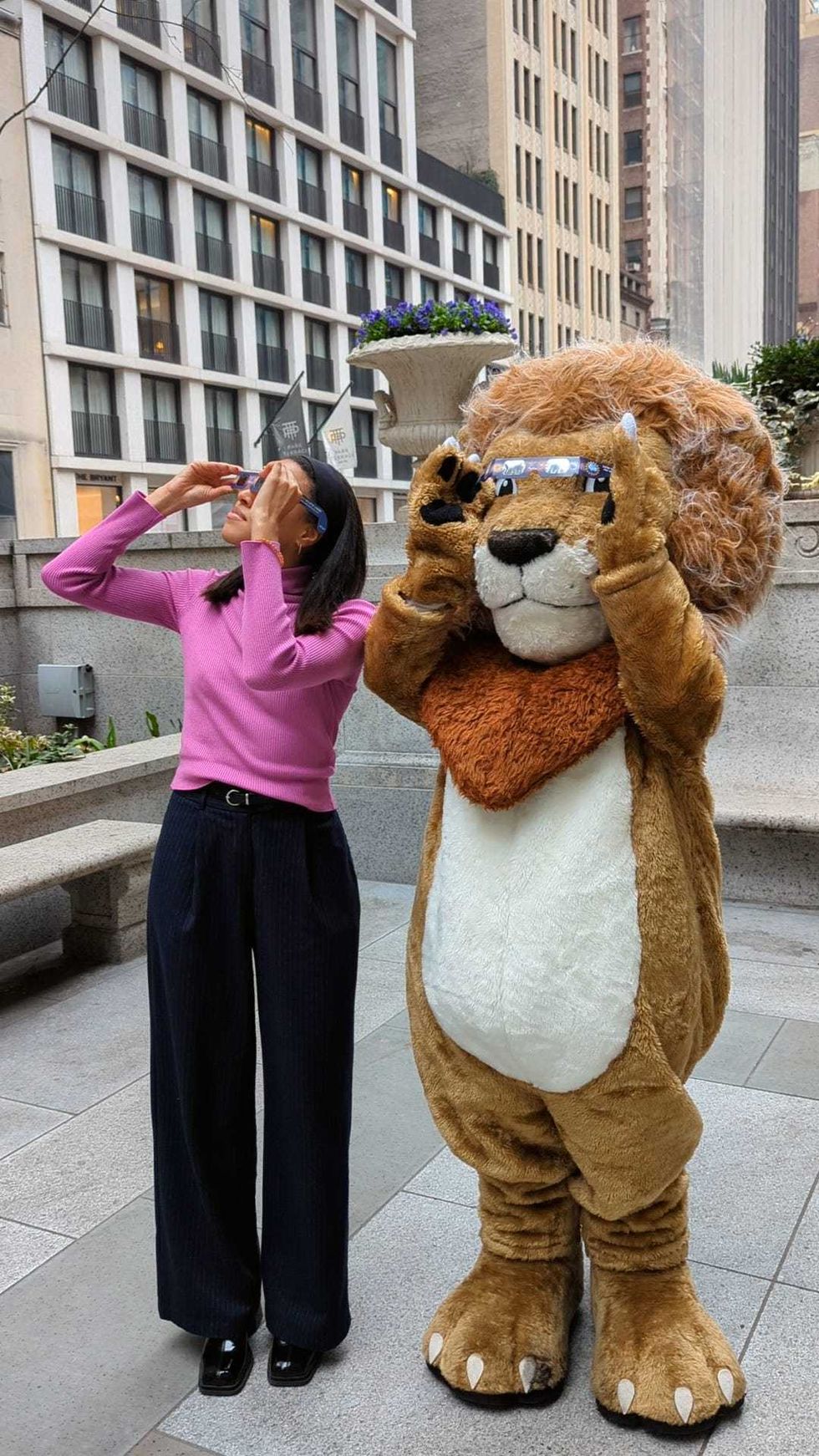 Patience Lion with a library-goer decked out in NYPL-provided eclipse glasses.