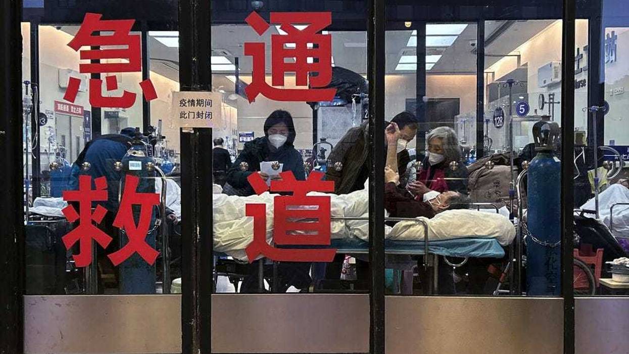 Patients and caregivers are seen in the closed entrance way of an emergency room being used as an overflow area at a hospital on January 14, 2023 in Shanghai, China.