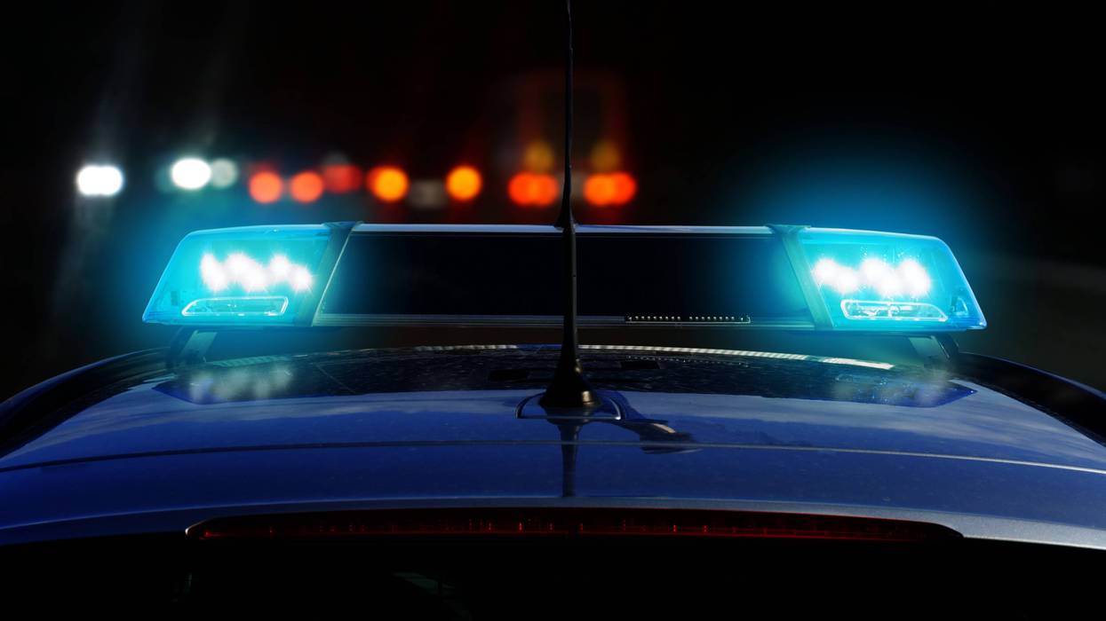 Patrol car on the road at night with flashing blue lights