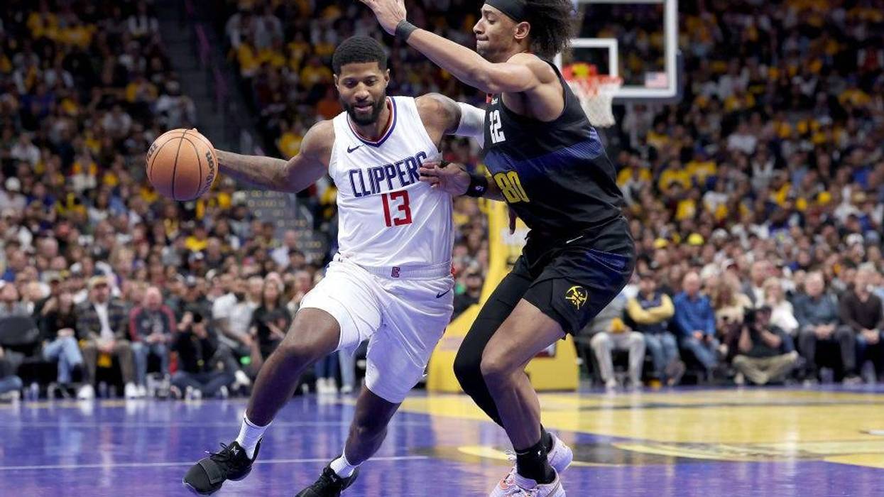 Paul George #13 of the Los Angeles Clippers drives against Zeke Nnaji #22 of the Denver Nuggets in the fourth quarter at Ball Arena on November 14, 2023 in Denver, Colorado.