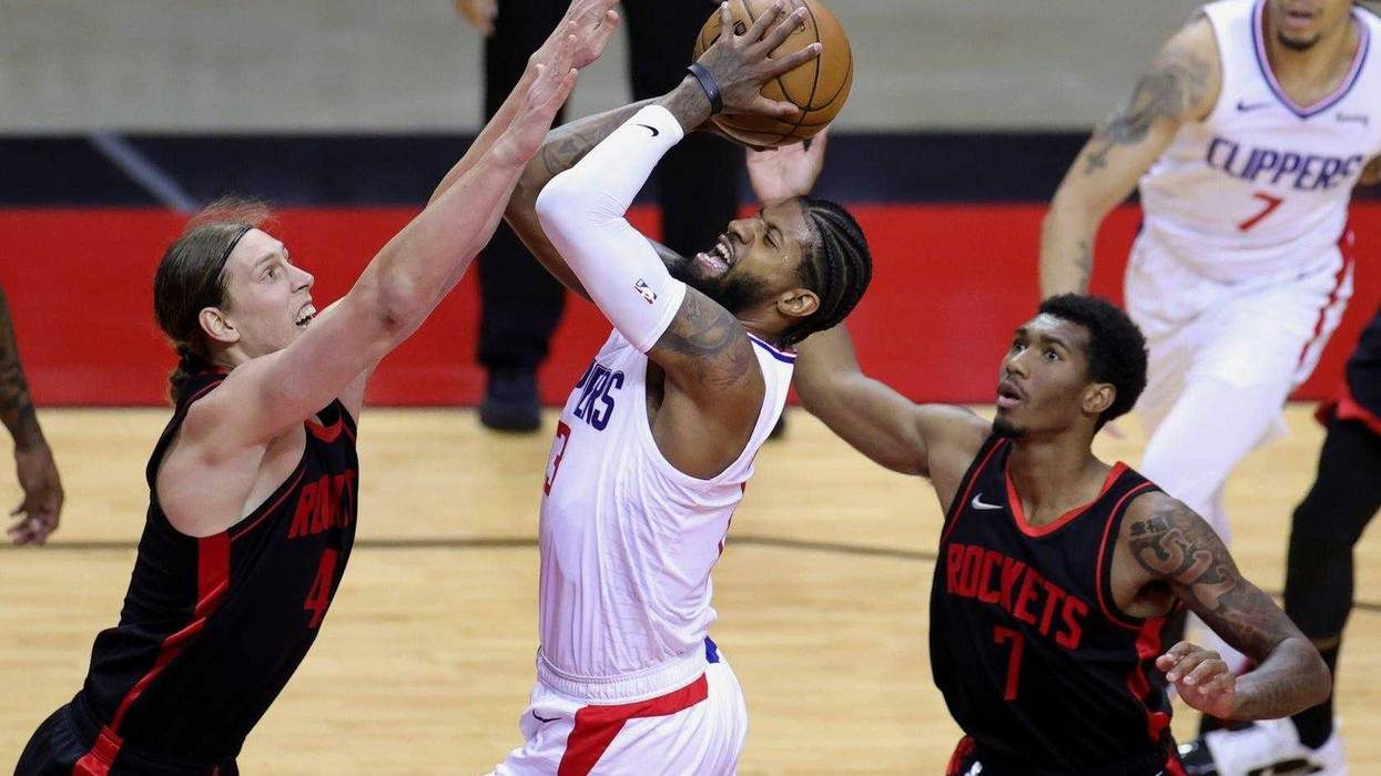 Paul George #13 of the Los Angeles Clippers looks to shoot against Kelly Olynyk #41 and Armoni Brooks #7 of the Houston Rockets during the second quarter at Toyota Center.