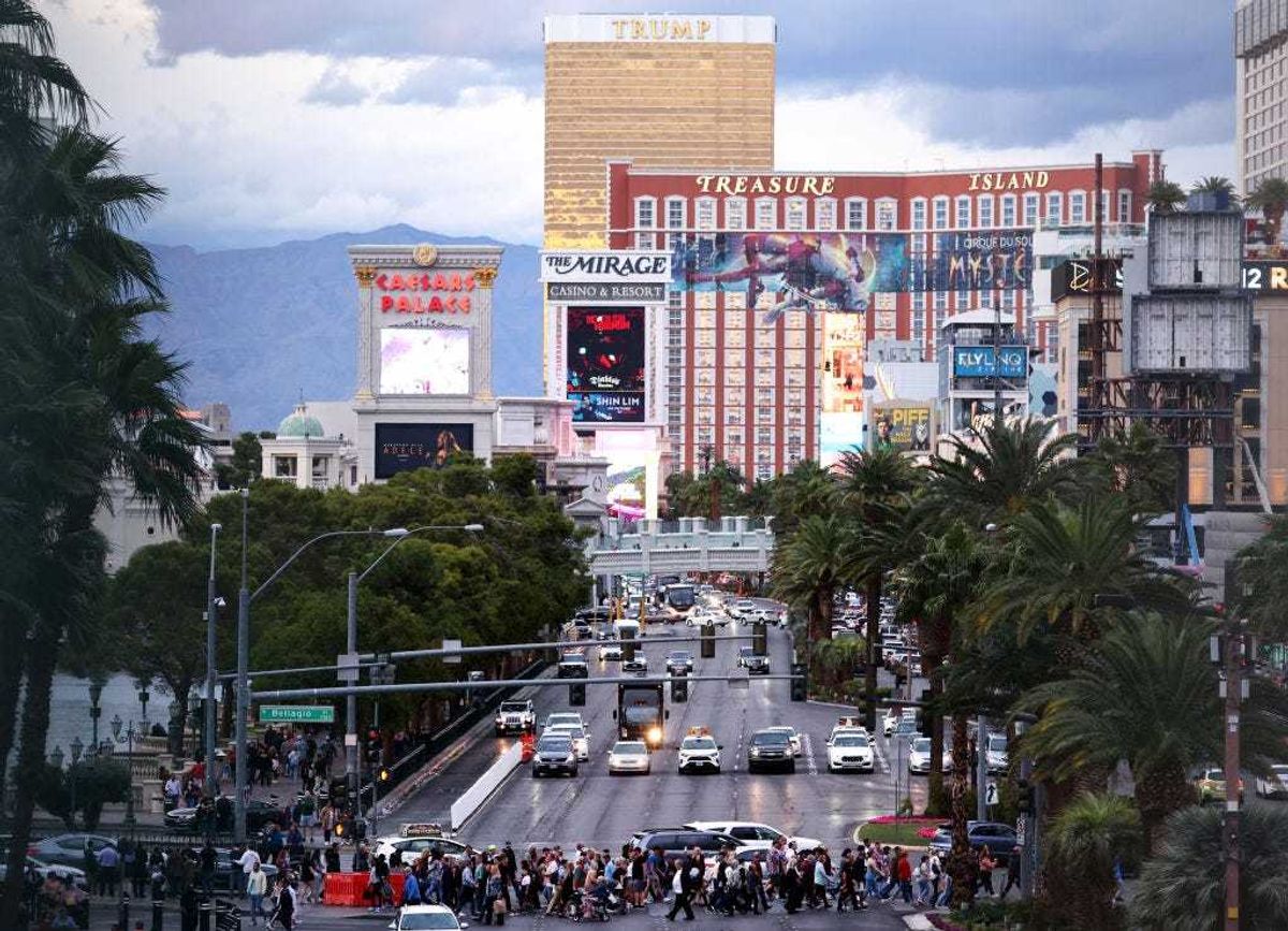 Pedestrians cross Las Vegas Boulevard along the Las Vegas Strip with the Trump International Hotel visible one day before midterms Election Day on November 7, 2022 in Las Vegas, Nevada.