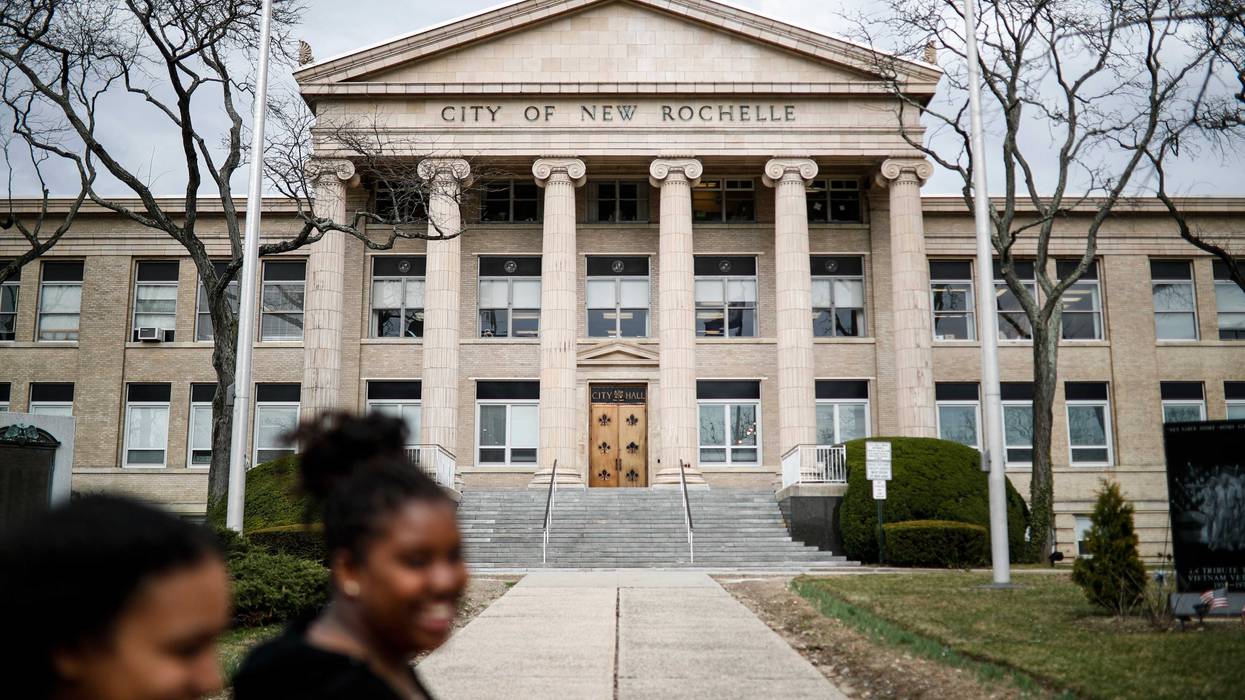 Pedestrians pass New Rochelle City Hall, Tuesday, March 10, 2020, in New York.