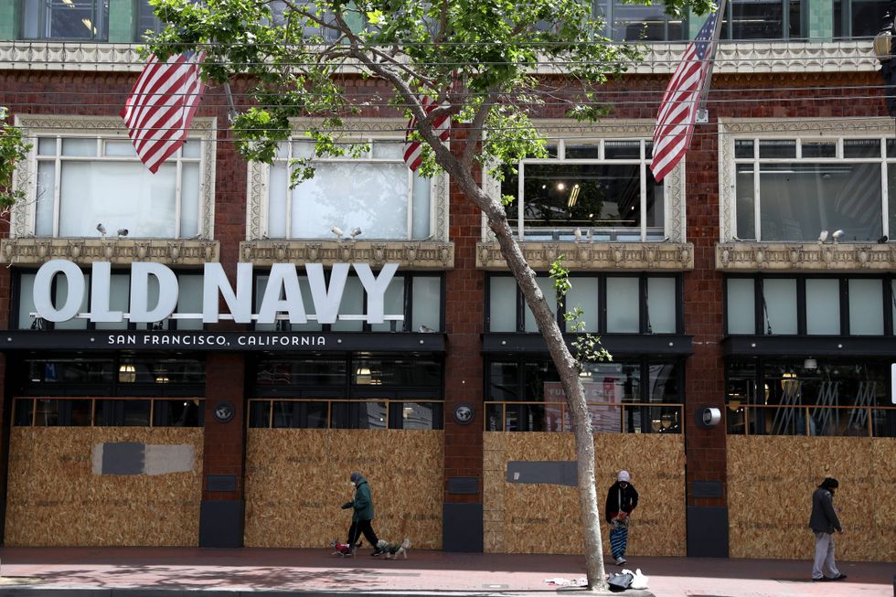 Pedestrians walk by a boarded up Old Navy store on May 15, 2020 in San Francisco, California.