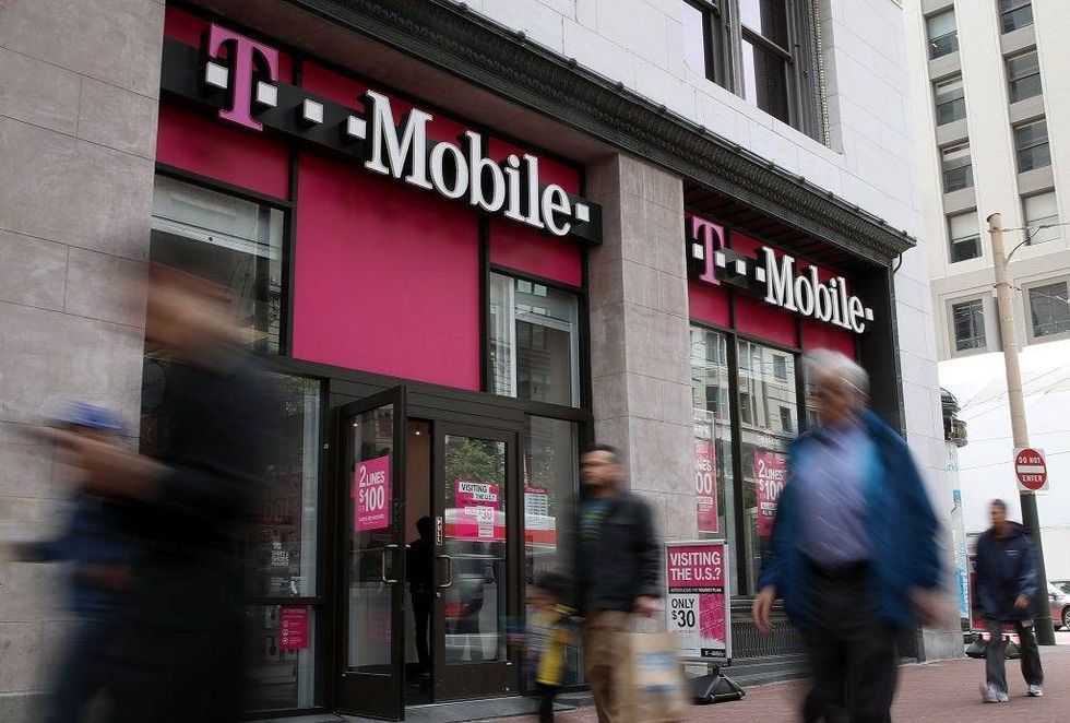 Pedestrians walk by a T-Mobile store