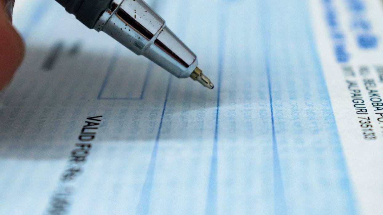 Pen poised over checkbook.