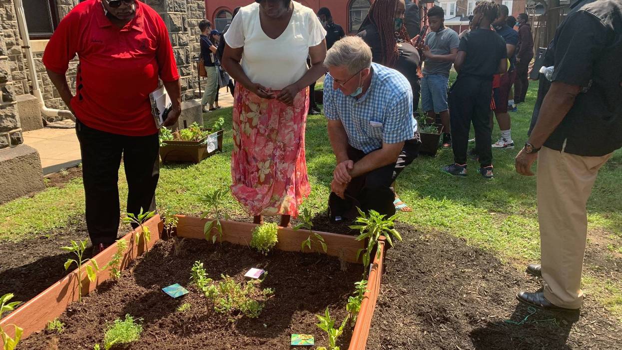Pennsylvania Agriculture Secretary Russell Reading (kneeling) in an Urban Ag Week event at Boys Latin Charter Middle School.