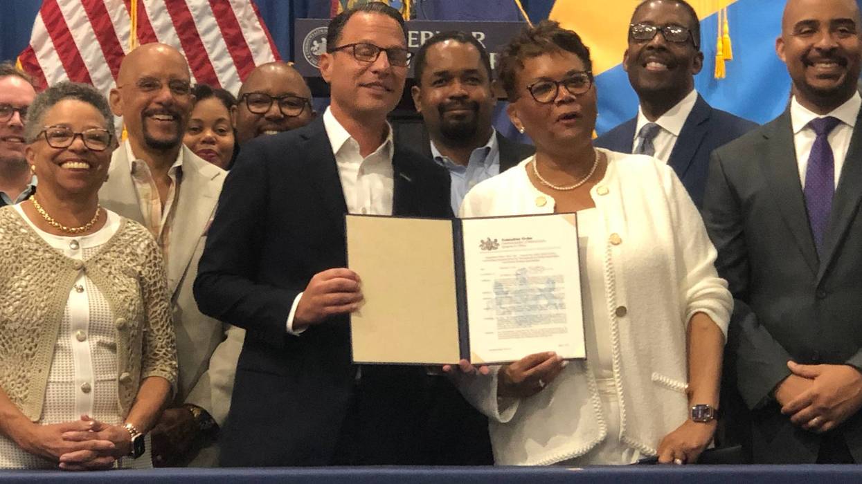 Pennsylvania Gov. Josh Shapiro (center), at Philadelphia's Enterprise Center, signs an executive order raising the revenue limit for small businesses to pursue state contracts.