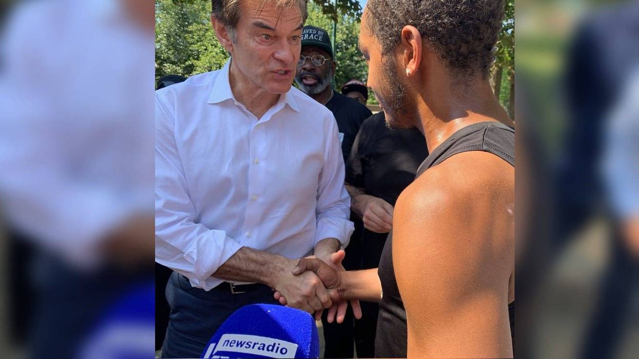 Pennsylvania Republican U.S. Senate candidate Mehmet Oz talks with a man battling addiction on Monday during a tour of Philadelphia.
