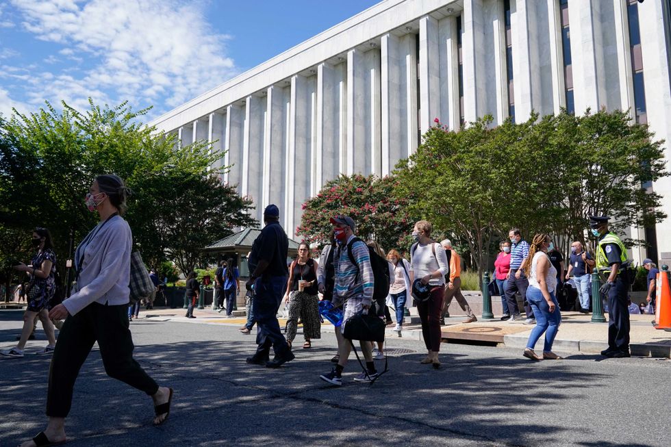 People are evacuated from the James Madison Memorial Building, a Library of Congress building, in Washington on Thursday, Aug. 19, 2021, as law enforcement investigate a report of a pickup truck containing an explosive device near the U.S. Capitol