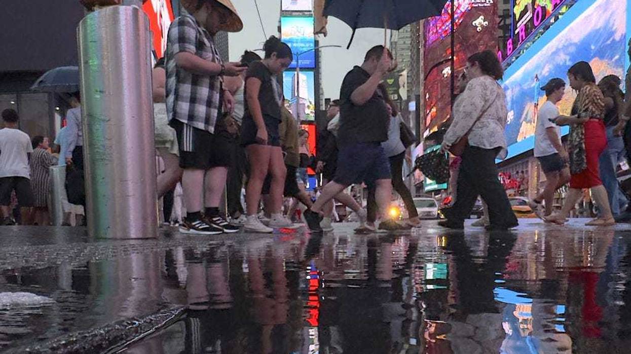 People are seen in Times Square during a rain storm in New York City, United States on August 2, 2024.
