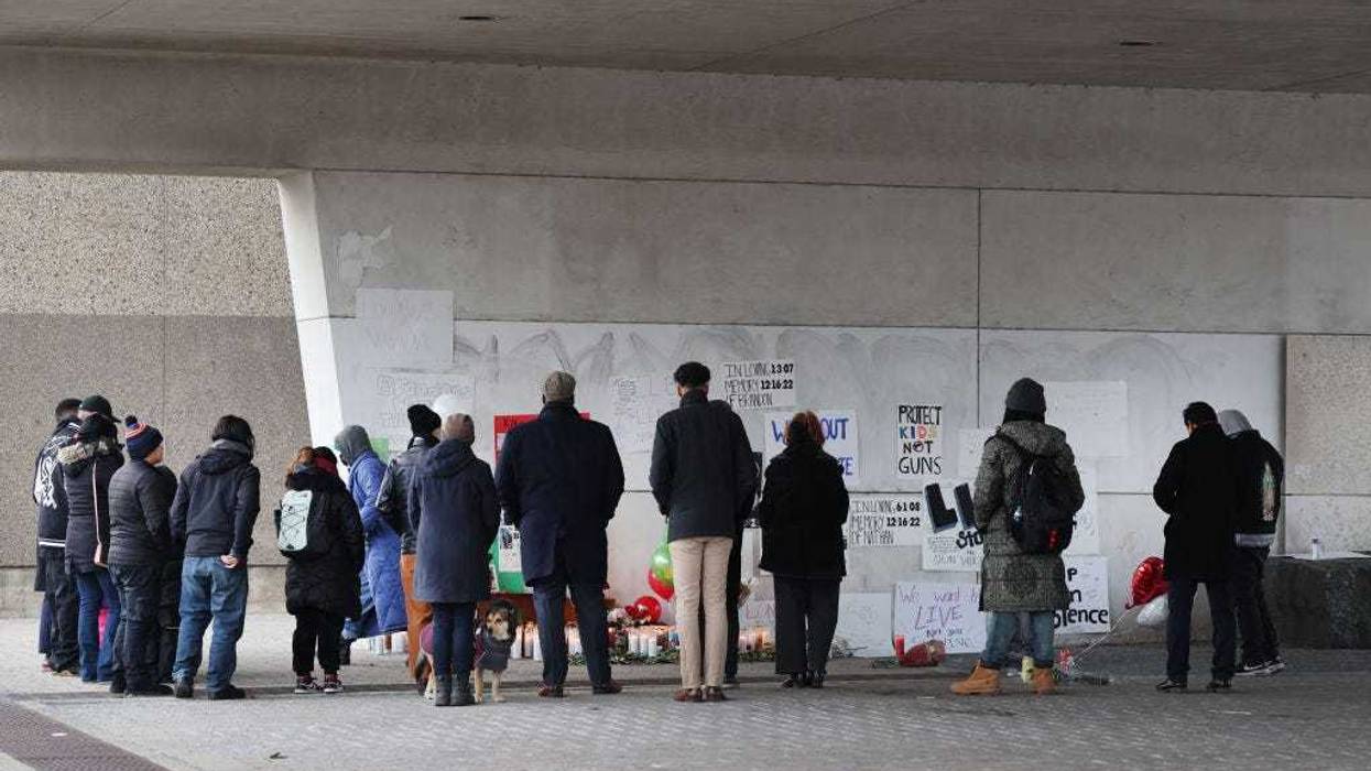 People attend a vigil outside Benito Juarez High School to mourn the deaths of Nathan Billegas, 14, and Brandon Perez, 15 on December 19, 2022 in Chicago, Illinois. Billegas and Perez were killed and two other teens, a boy and a girl, both 15, were wounded outside the school when a gunman opened fire as classes were being dismissed on Friday afternoon. (Photo by Scott Olson/Getty Images)