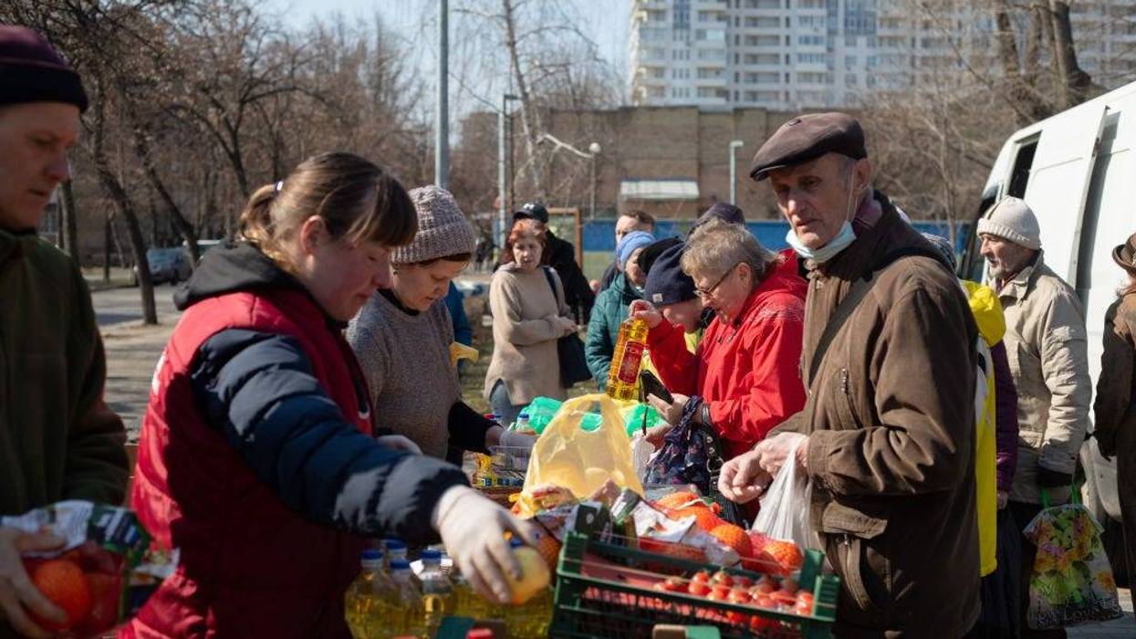 People buy groceries at the lot in the street on March 24, 2022 in Kyiv, Ukraine. Although few nights pass without shellfire or air strikes in some part of the capital, the advance of Russian ground forces here has largely stalled and, in some cases, has been repelled. (Photo by Anastasia Vlasova/Getty Images)