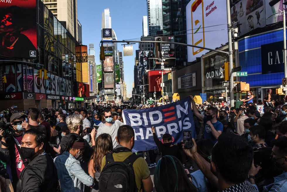 People celebrate in the streets after it was announced that Democratic nominee Joe Biden would be the next U.S. President, in Times Square on November 7, 2020 in New York City.