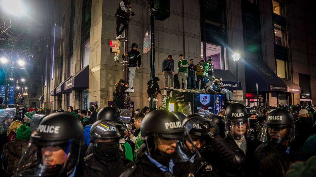 People climb poles following the Philadelphia Eagles' NFC championship win in Philadelphia, Jan. 26, 2025.