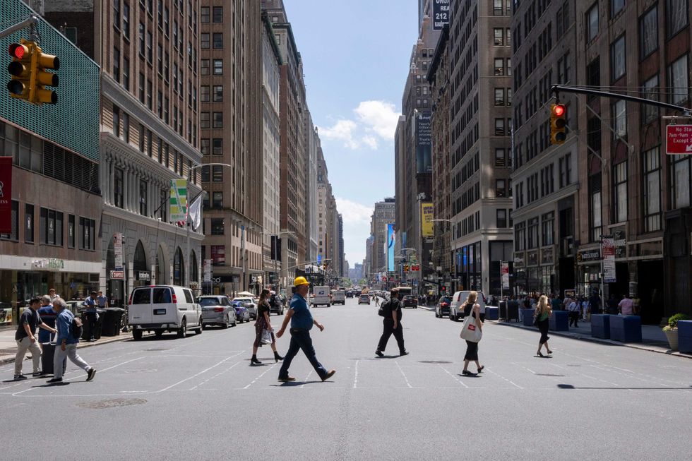 People cross 38th Street and Seventh Avenue in Midtown Manhattan during a heat wave on July 11, 2024