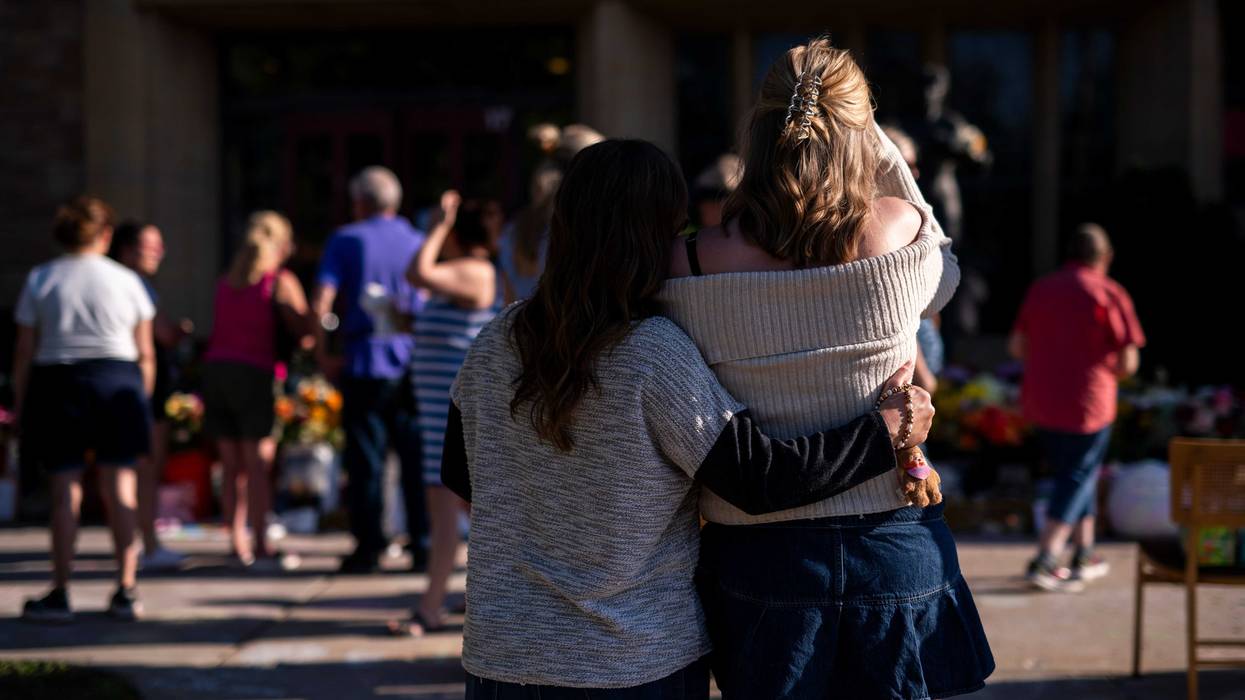 People embrace outside Annunciation Church and School on August 30, 2025 in Minneapolis, Minnesota.