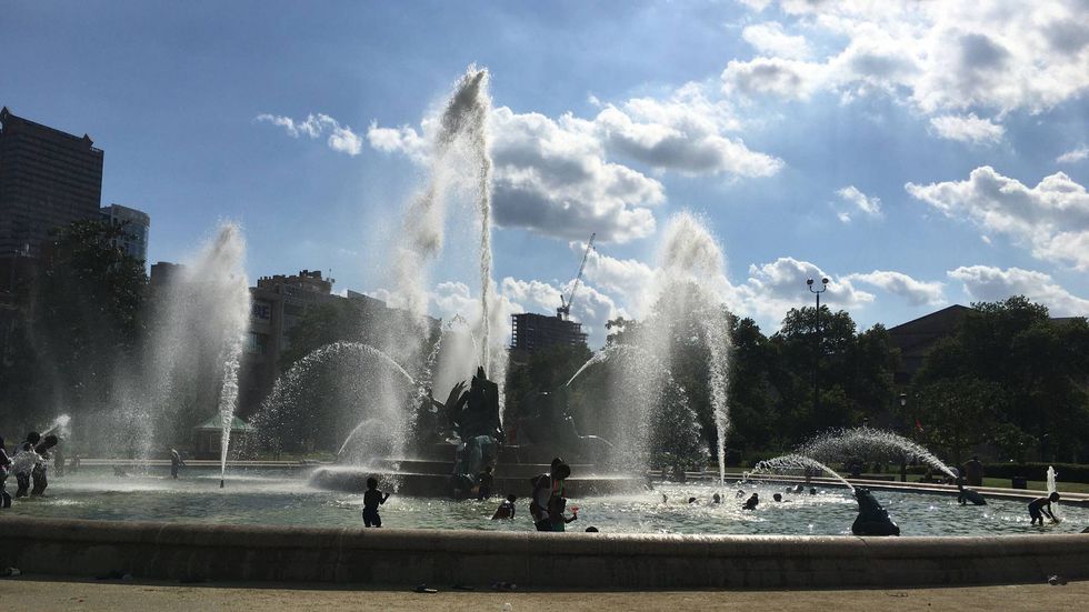 People enjoying the Swann Fountain at Logan Square during the late June heat wave in Philadelphia.