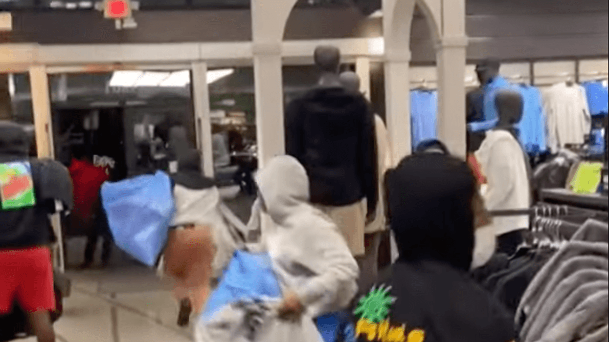 people filling bags with clothes in store